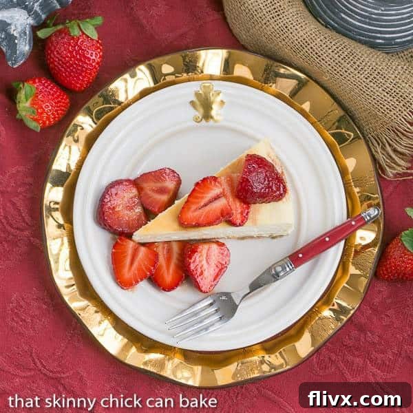 Slice of creamy Mascarpone Cheesecake topped with glistening sweetened balsamic strawberries on a white plate.