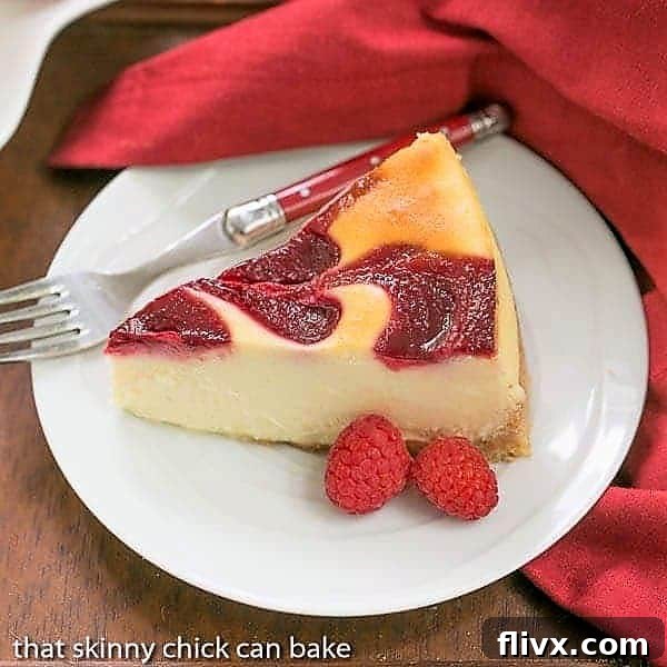 A slice of elegant White Chocolate Raspberry Swirl Cheesecake on a white plate, adorned with fresh raspberries.