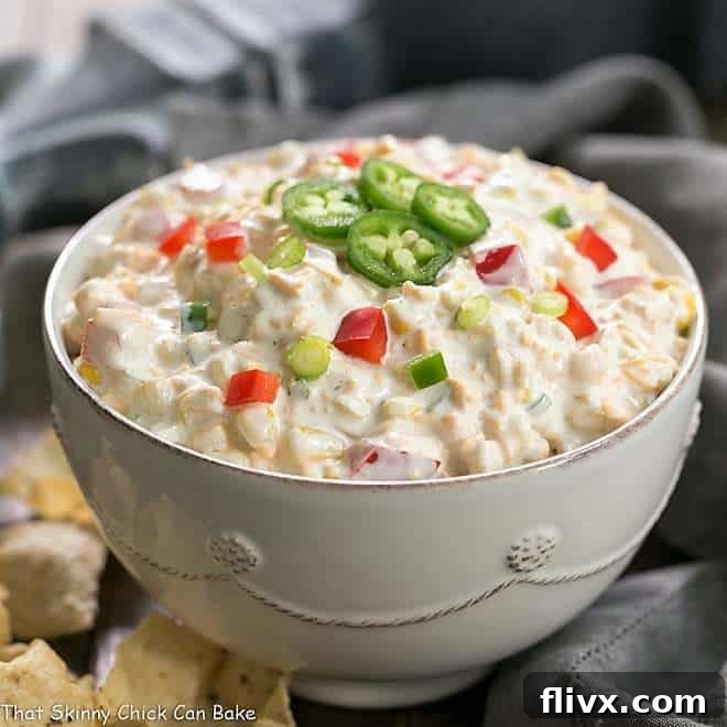 Creamy Sour Cream Corn Dip with a hint of spice, garnished with fresh herbs.