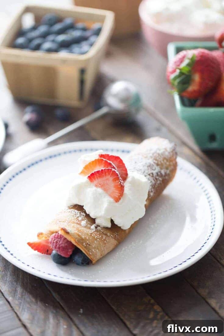 Red, white, and blue dessert crepes filled with berries and cream.