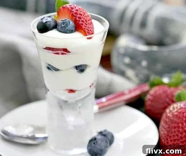 Mini white chocolate berry parfaits in glasses, layered with cream and mixed berries.
