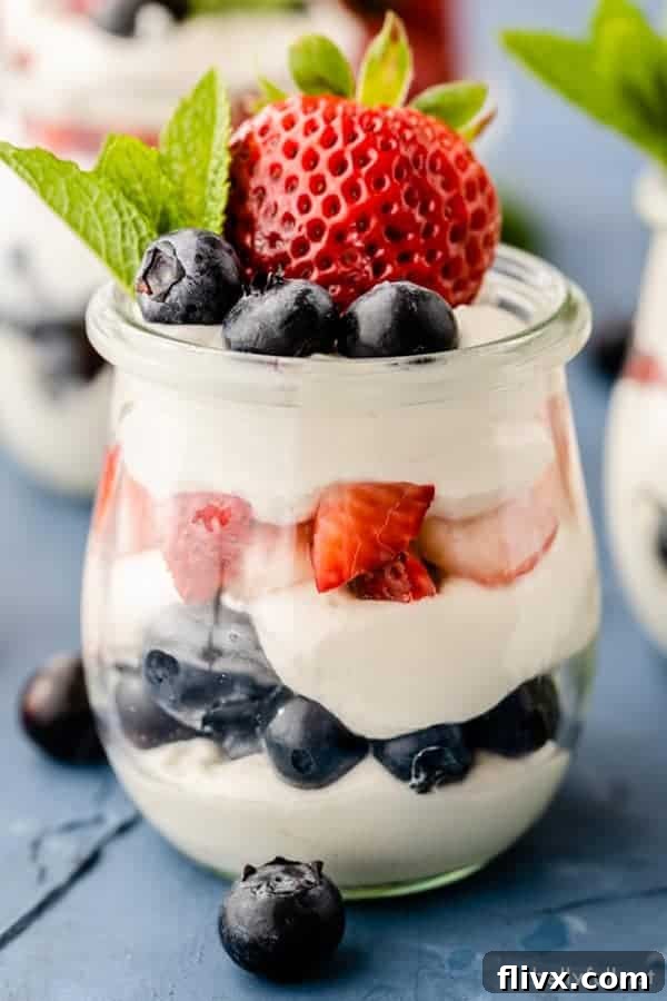 Red, white, and blue cheesecake mousse parfaits, elegantly layered in tall glasses.