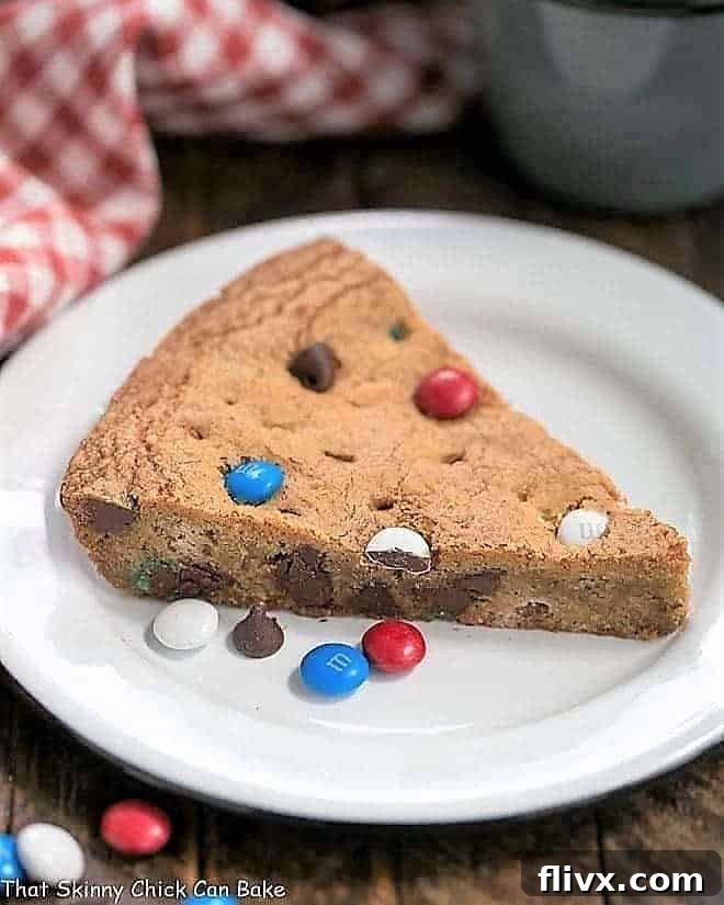 Wedges of a warm, gooey patriotic skillet cookie, topped with red, white, and blue candies.
