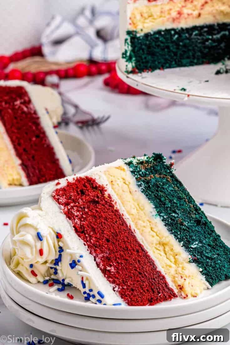 A slice of red, white, and blue velvet cheesecake cake, topped with fresh berries.