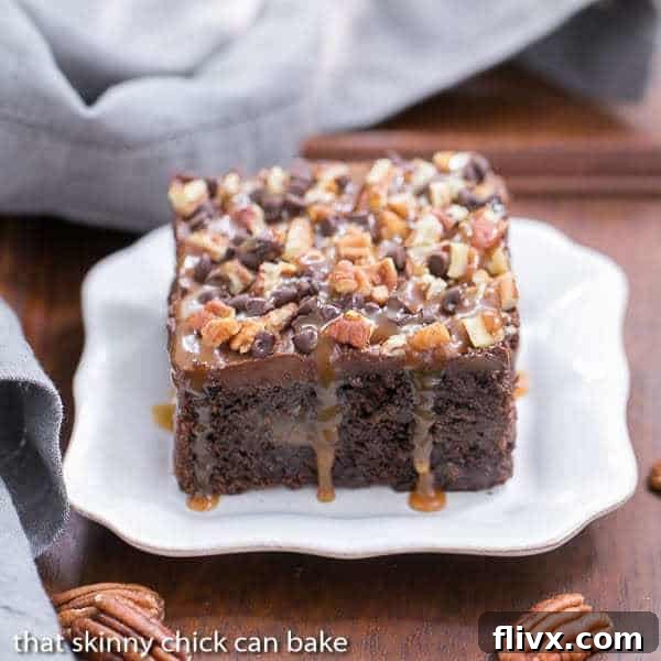 Decadent Turtle Poke Cake 2 A beautifully sliced Turtle Poke Cake, revealing layers of moist chocolate cake, rich caramel, creamy frosting, and pecan topping.