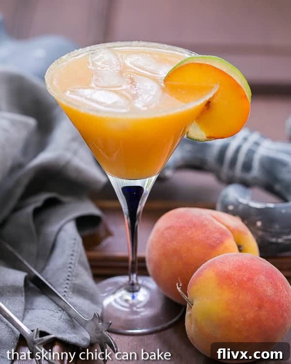 Fresh Peach Margaritas in a martini glass, garnished with a peach slice.