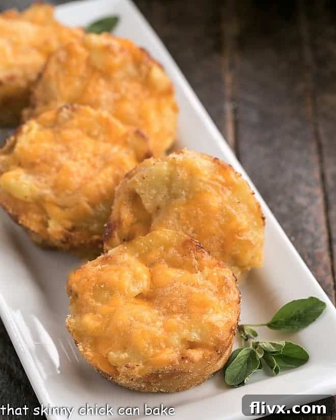 Close-up view of a ceramic platter showcasing golden, cheesy potato cups garnished with fresh oregano.