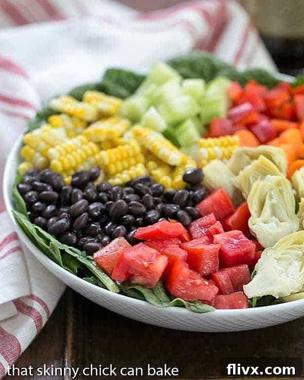 Summer Vegetable Salad in a white serving bowl, showcasing a rainbow of fresh vegetables.