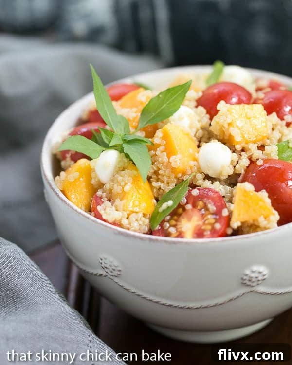 Vibrant Peach Quinoa Caprese Salad served in a pristine white bowl, showcasing fresh ingredients.