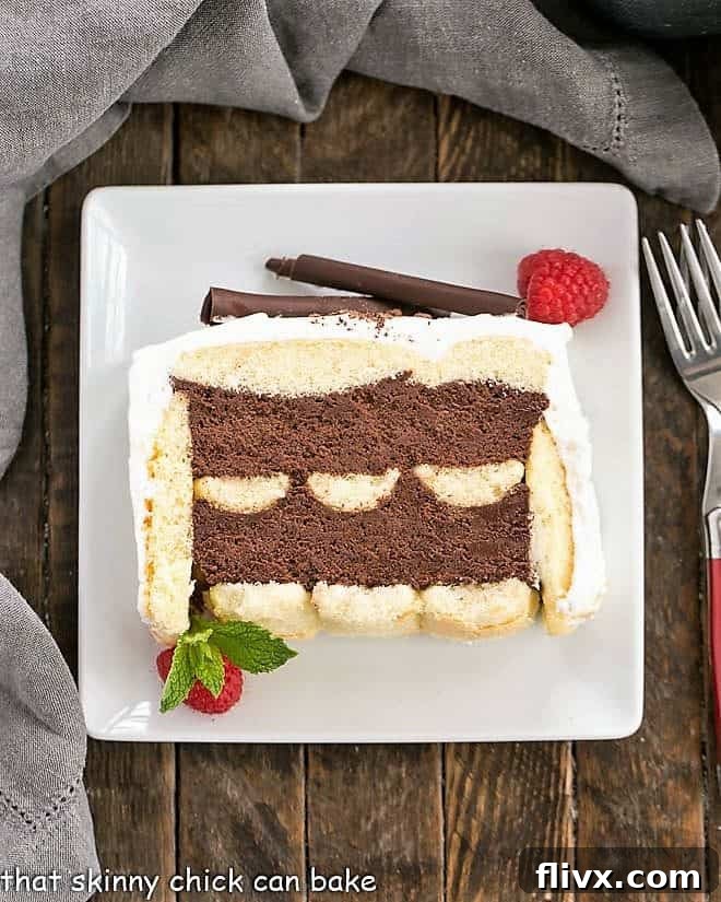 A delectable slice of No-Bake Chocolate Mousse Cake with Ladyfingers on a square white dessert plate, showing its intricate layers and creamy topping.