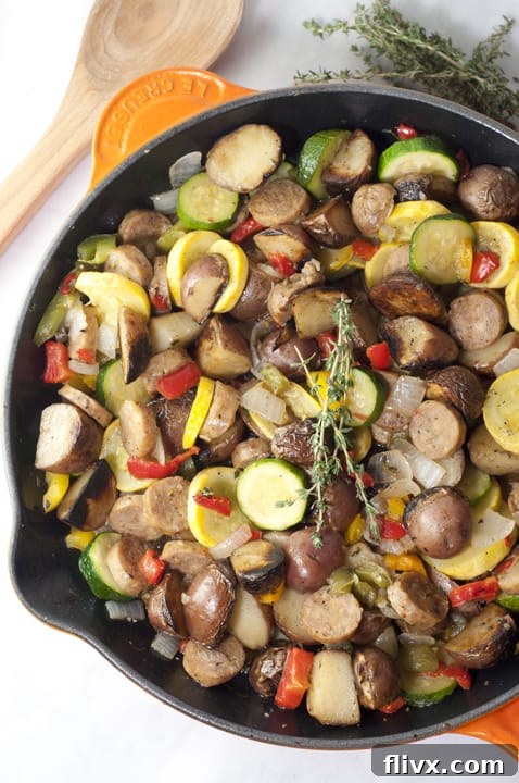 Sausage and Potato Summer Vegetable Skillet, a rustic dish filled with colorful vegetables and sliced sausage.