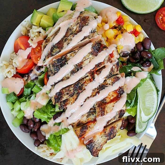 A vibrant Grilled Chicken Burrito Bowl, loaded with fresh ingredients like corn, black beans, avocado, and salsa.