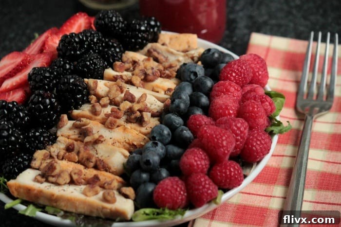 Grilled Chicken Summer Berry Salad featuring grilled chicken pieces and a vibrant mix of fresh summer berries on a bed of greens.