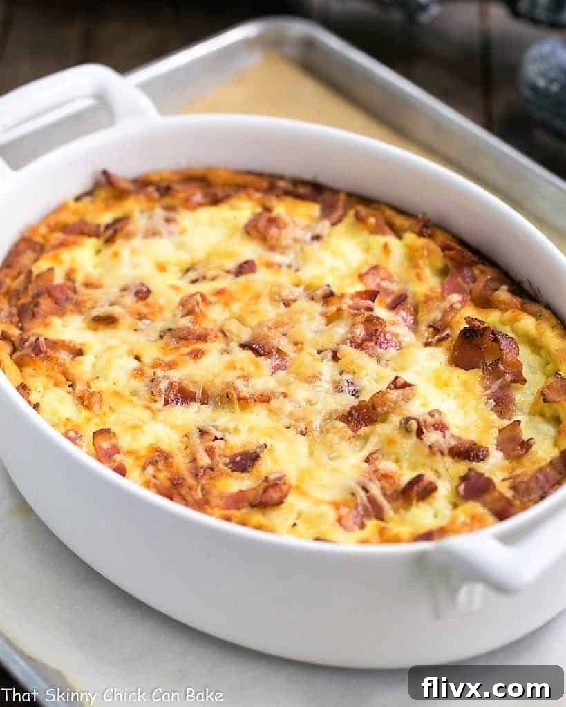 Cauliflower bacon gratin in a white baking dish on a sheet pan.