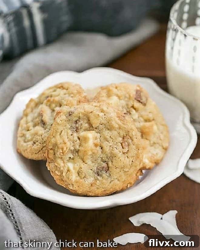 A white bowl full of white chocoate toffee chunk cookies