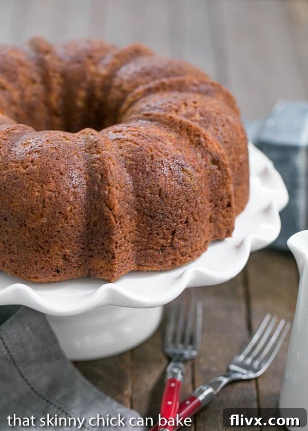 A slice of Apple Bundt Cake with a surprise cream cheese filling, showcasing its moist texture and beautiful swirl.