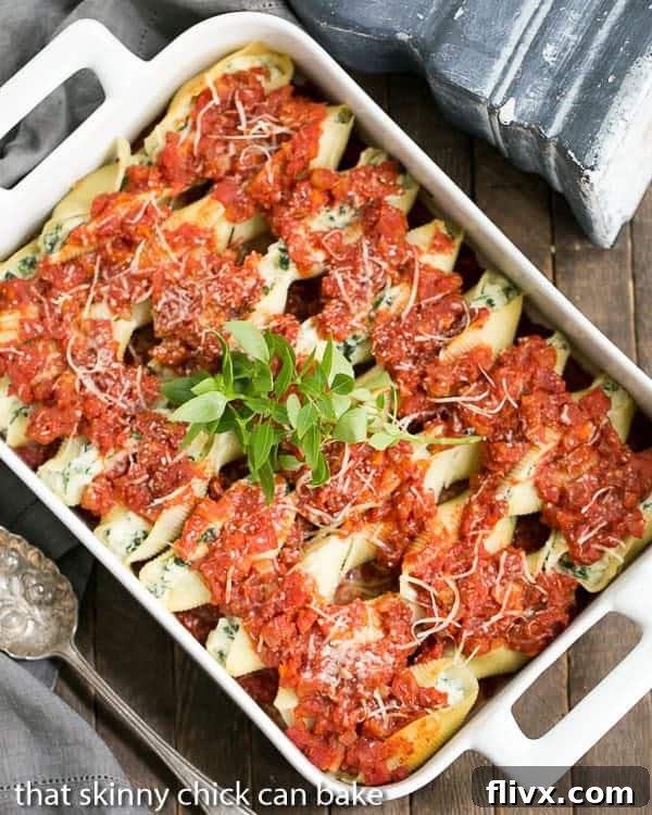 Spinach Stuffed Pasta Shells arranged in a casserole dish and covered with marinara sauce, ready for baking.