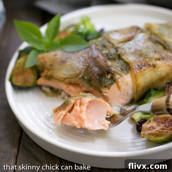 Close-up shot of Potato Shingled Salmon on a white plate with a forkful of salmon in focus, highlighting the crispy potato crust