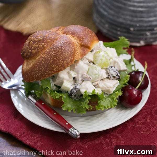 A plate of chicken salad on a bun over a red napkin