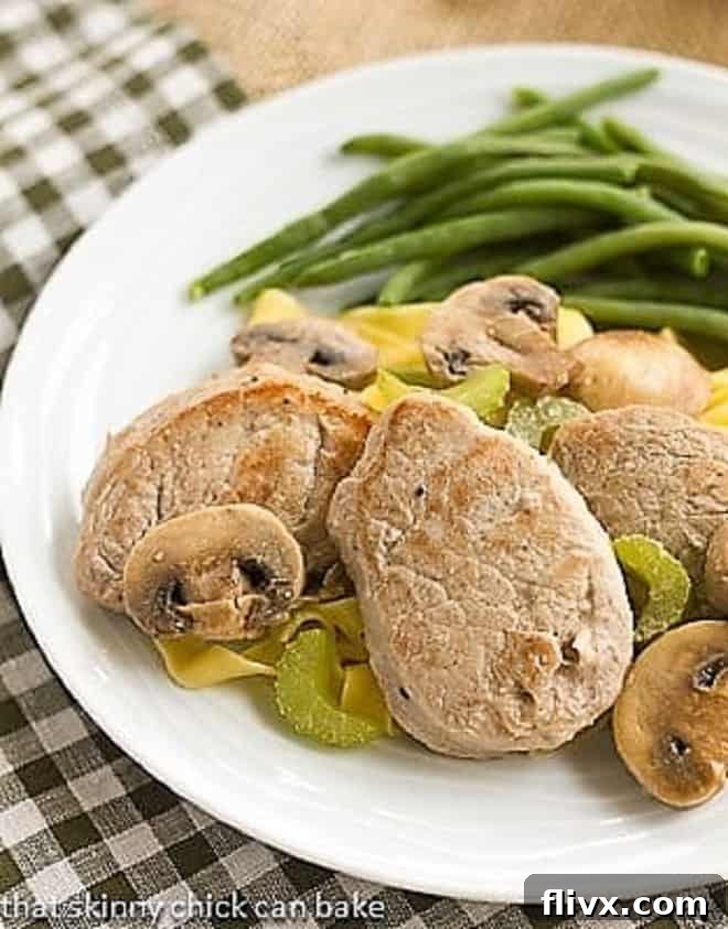 Easy Pork Scaloppine on a white plate with green beans.