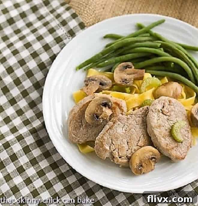 Overhead view of Easy Pork Scaloppine over egg noodles on a white dinner plate