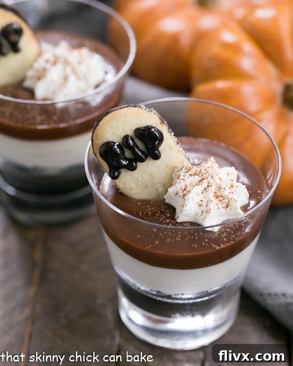 Delicious Fudgy Tombstone Parfaits with layers of Oreo crumbs, creamy no-bake cheesecake, and warm fudge sauce, garnished with a spooky tombstone cookie. Perfect Halloween dessert idea.