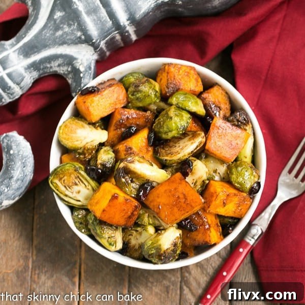 An inviting overhead view of a white bowl filled with Roasted Autumn Vegetables, showcasing vibrant colors and textures, with a red-handled fork resting beside it, ready to be enjoyed.