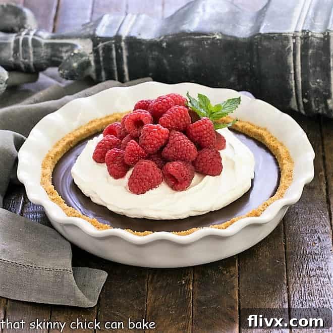 Luxurious Dark Chocolate Satin Pie, featuring a rich, fudgy filling crowned with a cloud of whipped cream and fresh berries.