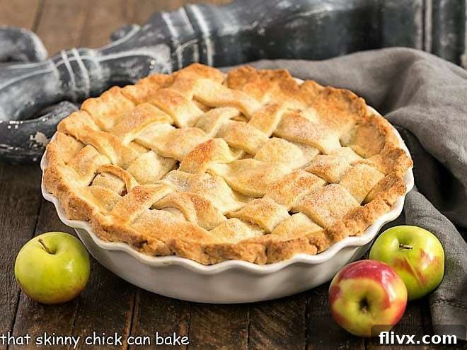 Slice of homemade apple pie with a golden flaky crust and a warm, spiced apple filling.