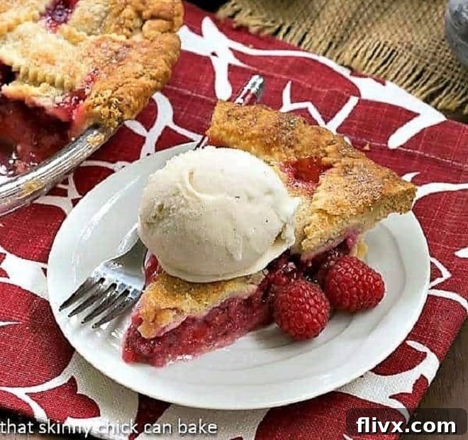 Vibrant Lattice Topped Raspberry Pie with a golden, woven crust over a glistening raspberry filling.