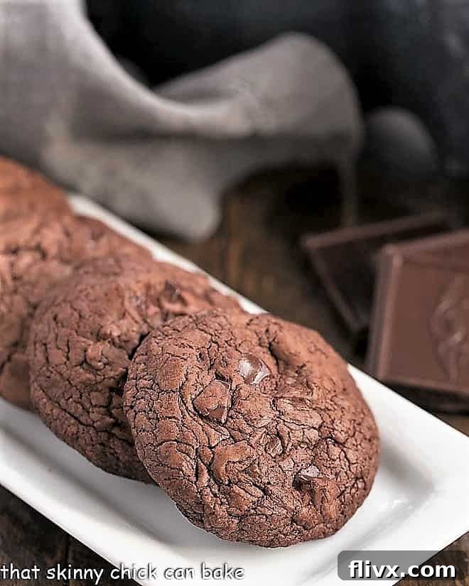 Black Gold Cookies lined up on a white rectangular tray, showing their appealing dark color and crackled tops