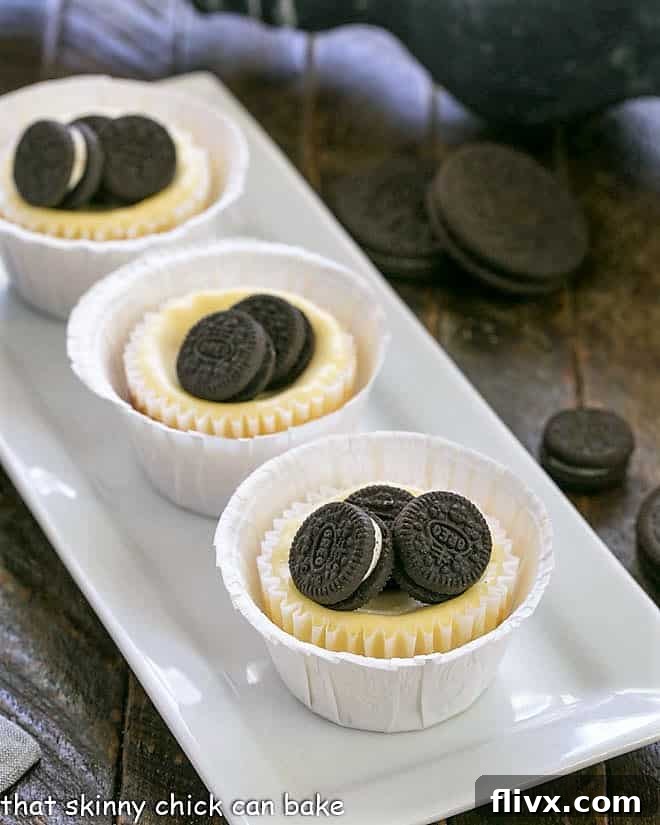 Mini Oreo Cheesecakes lined up on a white rectangular platter.
