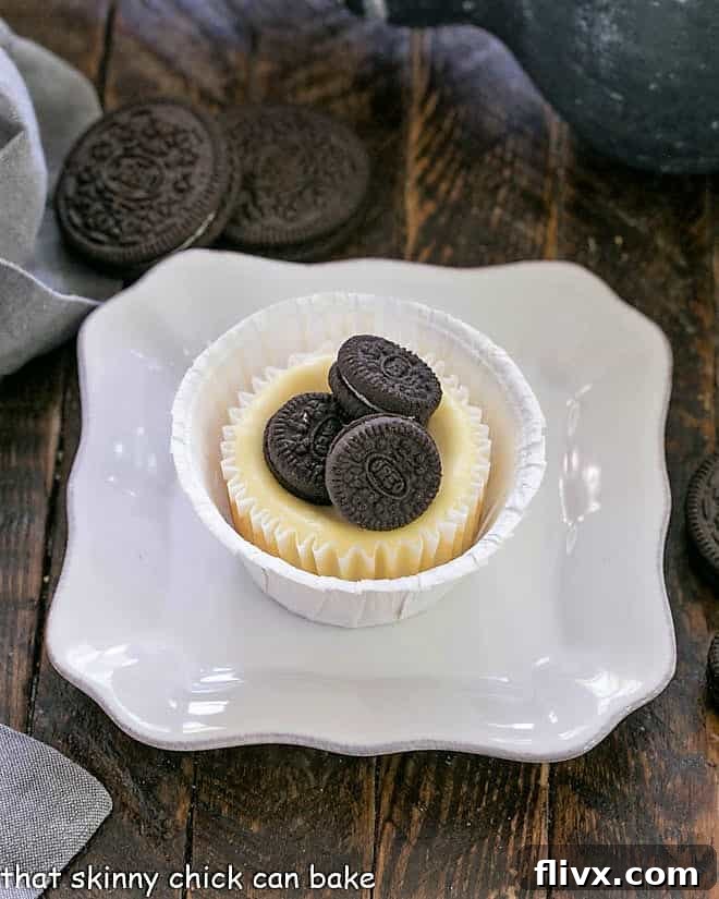 One Oreo cheesecake topped with 3 mini oreos on a square white plate