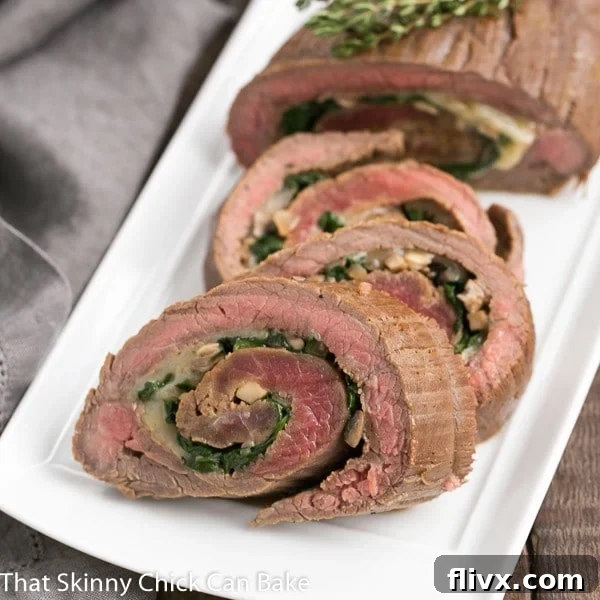 Flank Steak Roulades on a white rectangular tray, beautifully sliced and ready to serve.