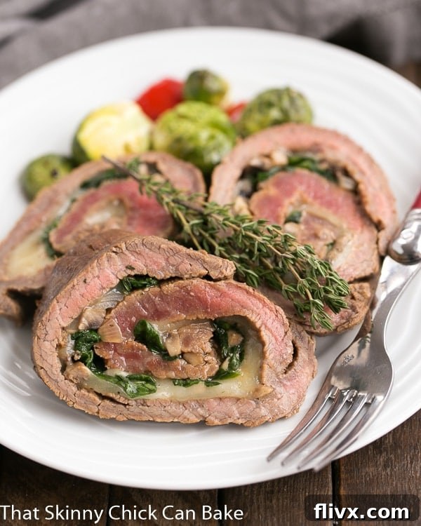 Close-up of a perfectly cooked Flank Steak Roulade, showing the vibrant spinach and mushroom filling.