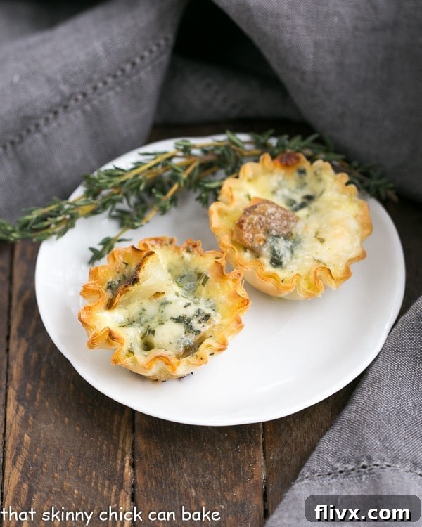 Potato Blue Cheese Tartlets are an easy, elegant and hearty appetizer! Potato Blue Cheese Tartlets on a round white plate with a sprig of thyme.