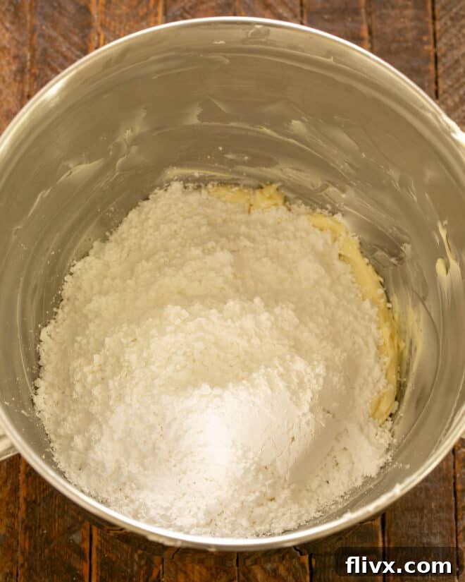 Butter and powdered sugar being beaten together for chocolate frosting.