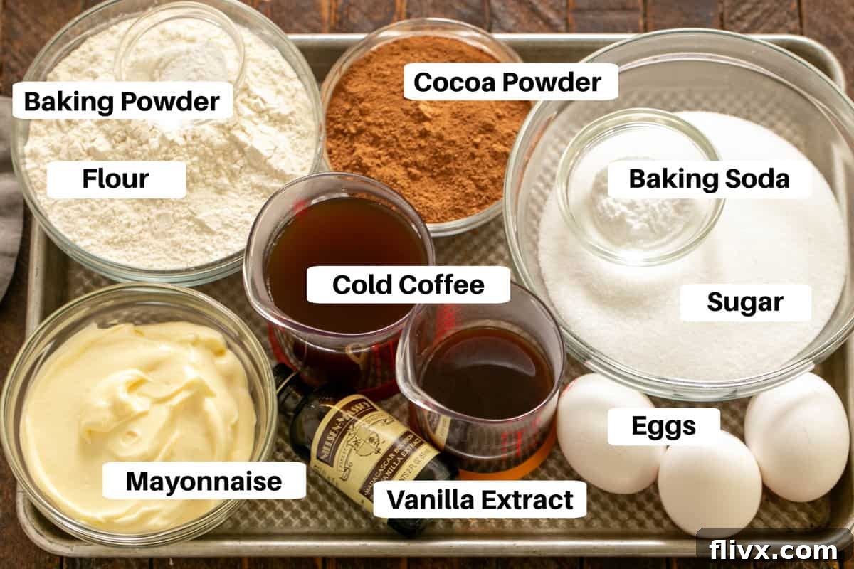Various ingredients for Chocolate Mayonnaise Cake laid out on a metal sheet pan, with labels.