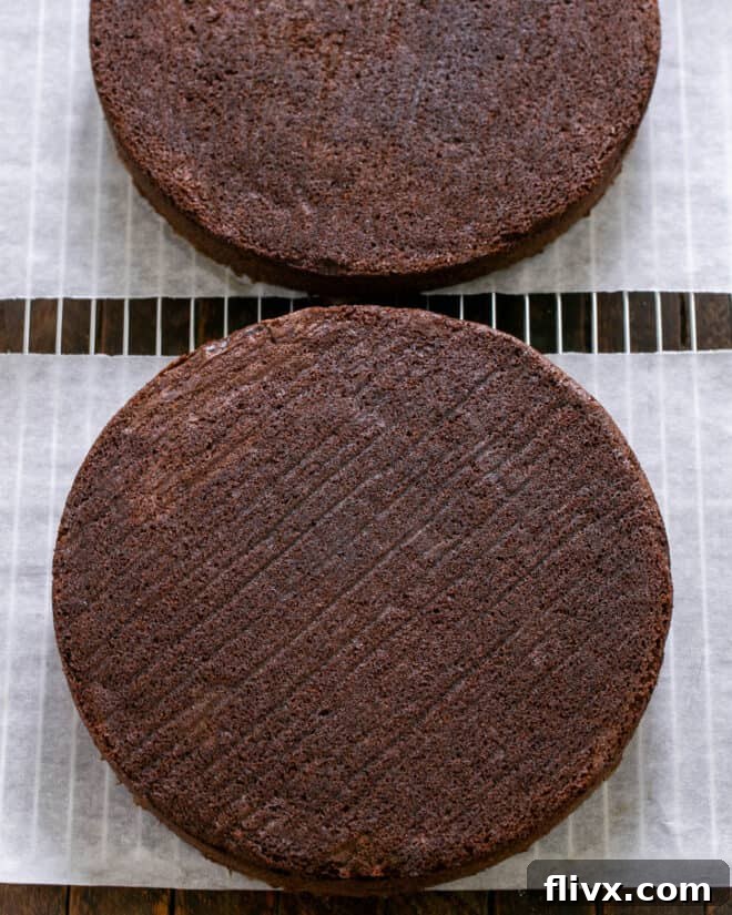 Baked cake layers cooling on wire racks after being removed from pans.