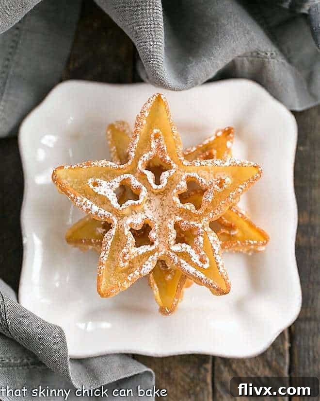 Two perfectly golden rosettes, delicately stacked on a square white plate, ready to be dusted.