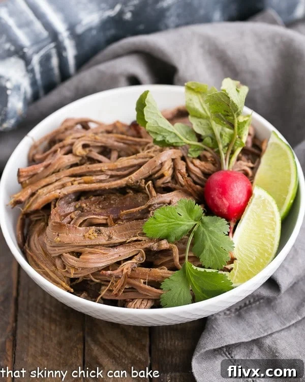 Slow Cooker Carne Asada in a white bowl with a radish and lime wedges
