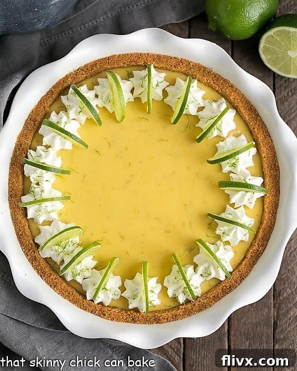 Key Lime Pie with Graham Cracker Crust in a pristine white ceramic pie plate, ready to be served.