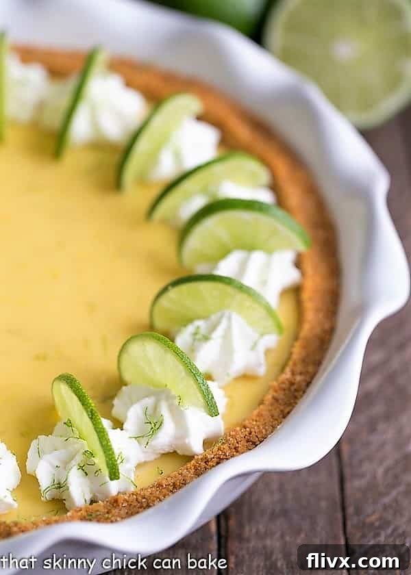 Close up view of the vibrant, creamy Key Lime Pie filling and golden graham cracker crust in a white pie plate