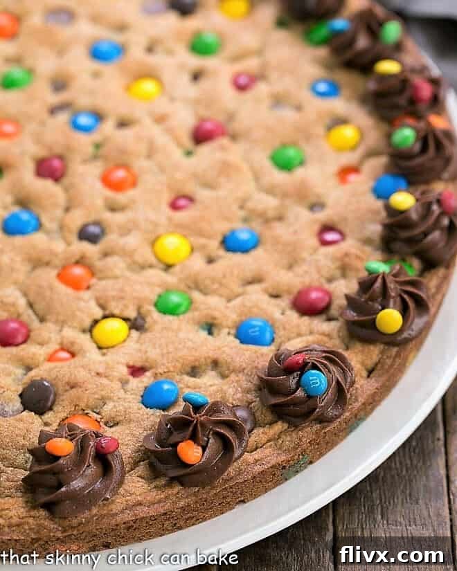 A vibrant close-up of a homemade chocolate chip cookie cake with M&M's, showcasing its rich, chewy texture and colorful candy pieces, promising a delightful bite.