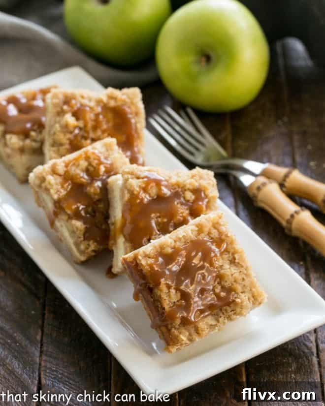 Decadent Caramel Apple Cheesecake Bars on a pristine white ceramic plate, ready to be enjoyed with two elegant forks.