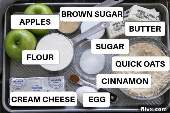 A thoughtfully arranged collection of fresh ingredients for Caramel Apple Cheesecake Bars, neatly laid out on a sheet pan with clear labels for easy identification.