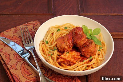 A bowl of Spaghetti with Sunday Gravy, featuring visible meatballs and rich tomato sauce, ready to be enjoyed.