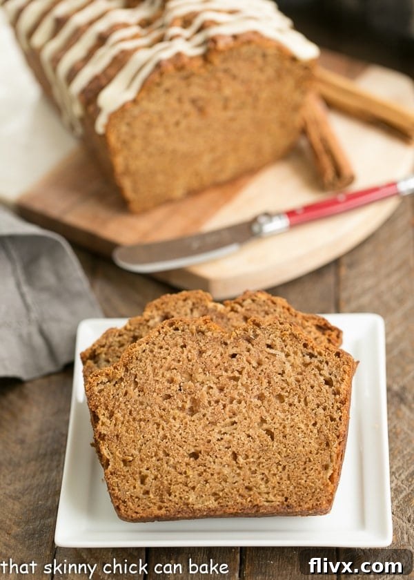 Close-up shot of perfectly sliced Brown Sugar Apple Bread, showcasing its moist crumb and tender texture, served on a pristine white plate.