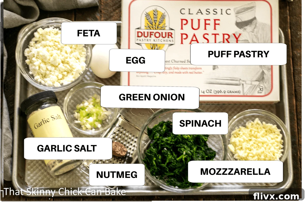 A sheet pan displaying all the distinct ingredients for Spinach Feta Pinwheels, clearly labeled for easy identification.