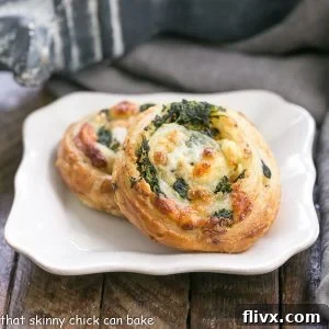 Two spinach feta pinwheels on a white plate, showcasing their inviting golden crust and savory filling.